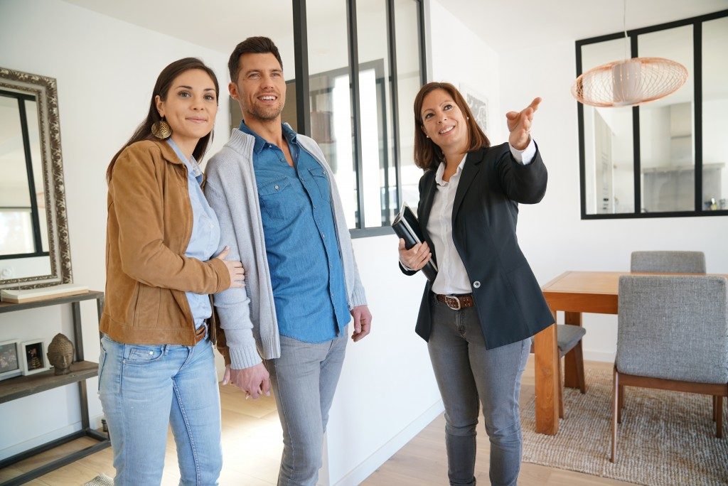 couple looking at model house with real state agent