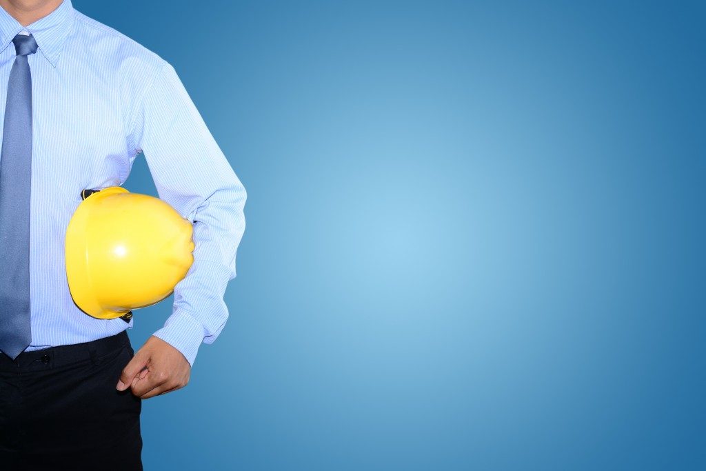 man in corporate attire with safety helmet