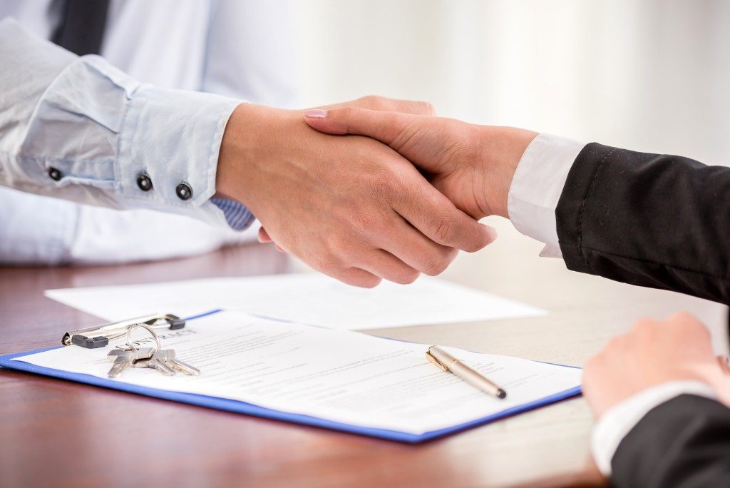 real estate agent and client shaking hands