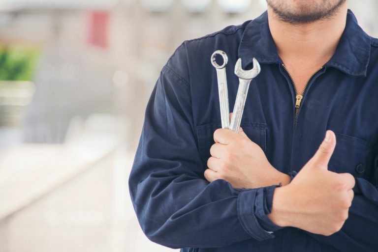 man holding tools and giving thumbs up