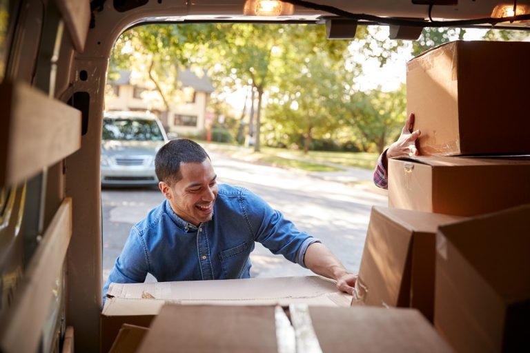 man loading box in van