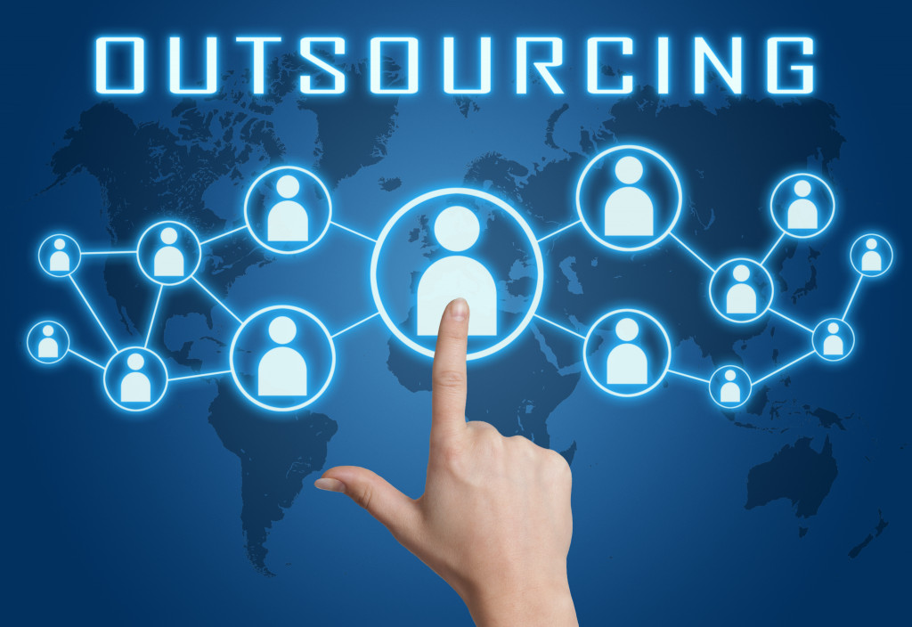 a hand pointing at an icon representing outsourcing