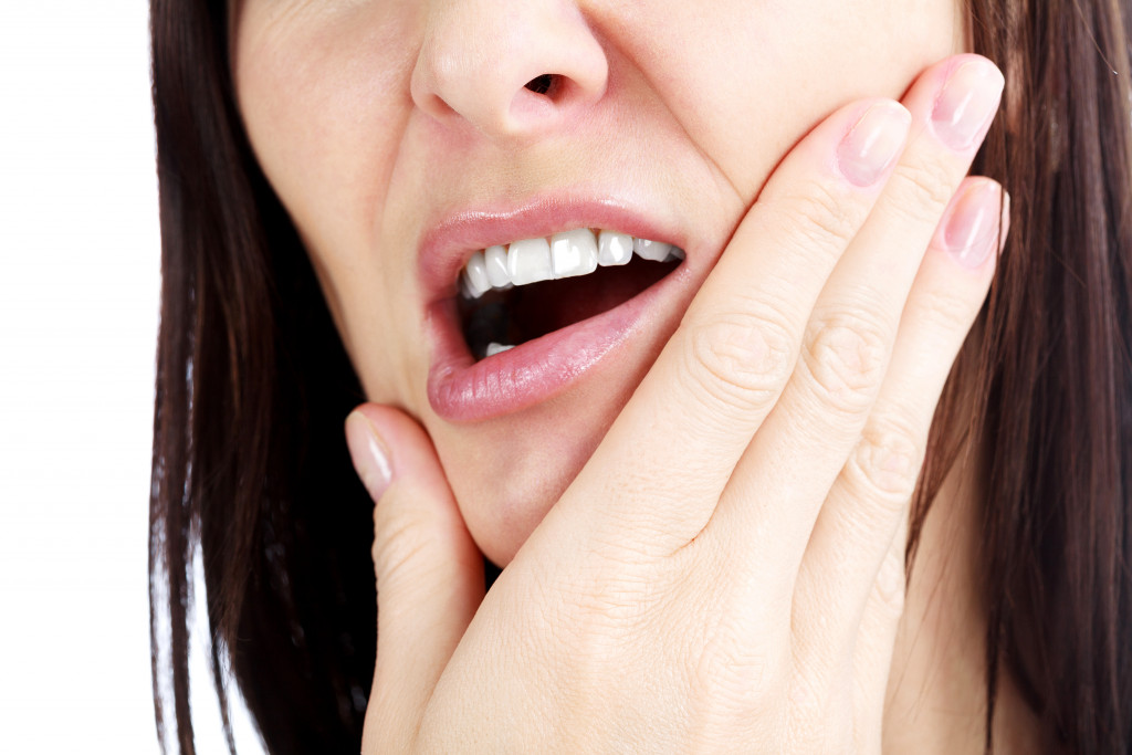 A woman experiencing jaw pain due to sensitivity