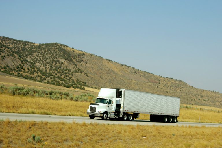 a white truck going on an uphill highway