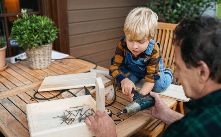A senior man doing a DIY project with a kid